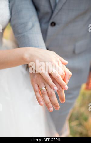 Frisch verheiratetes Paar, das draußen Hände hält Stockfoto