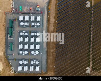 Luftbild der National Grid Walpole Unterstation Batteriespeichersysteme und der angrenzenden Solarfarm-Paneele, die in ordentlichen Reihen in Walpole, England, angeordnet sind, Stockfoto