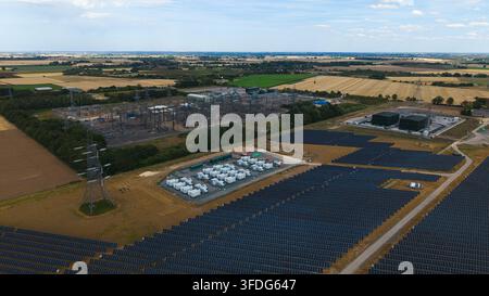 Luftbild der National Grid Walpole Unterstation und des angrenzenden Solarparks mit Batteriespeichersystemen, umgeben von landwirtschaftlichen Feldern in Walpole, Eng Stockfoto