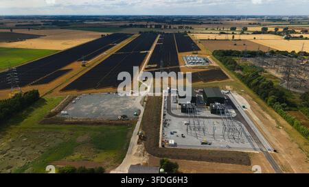 Luftbild der National Grid Walpole Unterstation und des angrenzenden Solarparks, umgeben von landwirtschaftlichen Feldern und Stromleitungen in Walpole, England, Vereinigtes Königreich Stockfoto