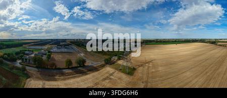 Luftaufnahme der National Grid Walpole Unterstation, umgeben von landwirtschaftlichen Feldern, goldenen Feldfrüchten und Stromleitungen unter einem blauen Himmel in Walpole, Engl Stockfoto