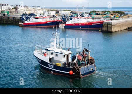 Frankreich, Guilvinec, 04.08.2026. Ein Fischkutter kehrt nach dem Entladen des Tagesfangs in den Hafen zurück. Stockfoto