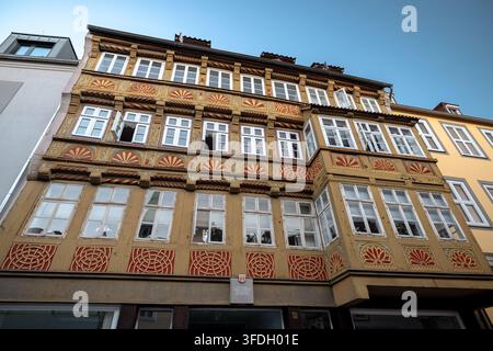 Niedrigwinkelaufnahme einer aufwendig verzierten historischen Fachwerkfassade mit geschnitzten und bemalten Zierpaneelen in der Altstadt von Hannover. Stockfoto