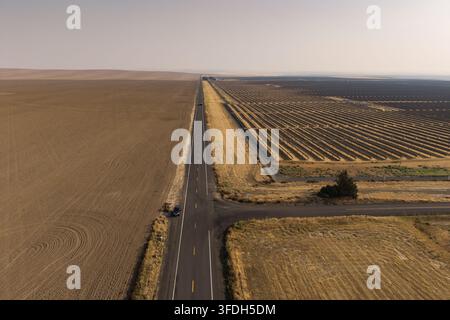 Luftbild der Solarfarm Arlington mit Reihen von Photovoltaikmodulen neben einer ländlichen Straße und weitläufigen trockenen landwirtschaftlichen Feldern in Arlington, Oregon, U Stockfoto