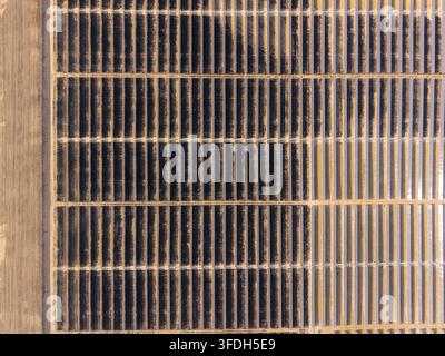 Luftaufnahme der Arlington-Solarfarm mit langen Reihen von Photovoltaikpanelen, die in einem Rastermuster über eine trockene Landschaft in Arlington, Oregon, angeordnet sind Stockfoto