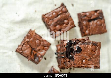 Stapel hausgemachter Schokoladen-Brownies mit umgebenden Browniestücken und Platz für Text. Stockfoto