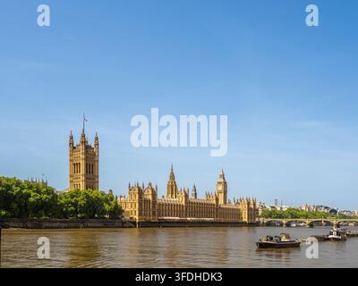 Palast von Westminster und Boote auf der Themse, gesehen vom Albert Embankment, London, England, UK. Stockfoto