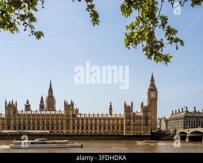 Palast von Westminster und Westminster Bridge mit einem Flussbus auf der Themse, London, England, UK. Stockfoto