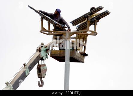 KARACHI, PAKISTAN - 31-Aug-2026: Techniker führten Wartung und Reinigung neu installierter Solarstraßenlaternen auf der Shahrah-e-Faisal-Straße in Karachi am Montag durch, unter Aufsicht von örtlichen Regierungsbeamten. Diese Initiative zielt darauf ab, die städtische Infrastruktur zu verbessern und nachhaltige Energielösungen in der Stadt zu fördern. Die Arbeiter operierten von einem Scherenkran aus, um die industriellen Beleuchtungsstrukturen zu erreichen, die mit großen, flachen Paneelen ausgestattet sind. Das Projekt steht für das Engagement, öffentliche Einrichtungen zu modernisieren und den Energieverbrauch zu reduzieren, im Einklang mit breiteren Umweltzielen. Stockfoto