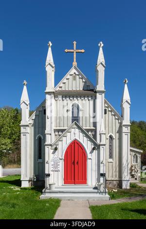 Die St. Paul's Episcopal Church, ein weißes hölzernes neogotisches Gebäude mit spitzen Türmen, einem hölzernen Kreuz und einer hellroten gewölbten Tür, steht unterhalb Stockfoto