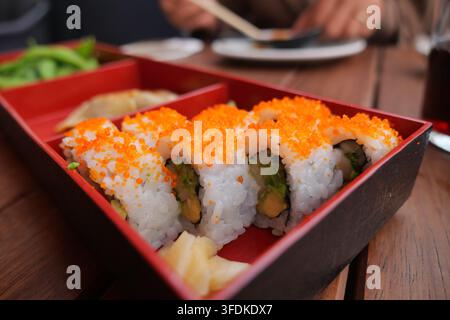 Sushi in einem Restaurant an einem Holztisch genießen Stockfoto