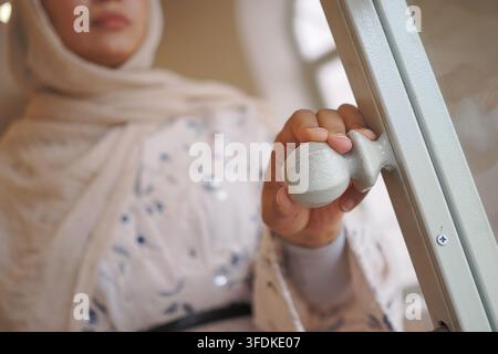 Frau öffnet eine Tür in einem hellen Raum Stockfoto