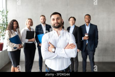 Selbstbewusster Arabischer Geschäftsmann, Der Vor Den Mitarbeitern Im Büro Steht Stockfoto