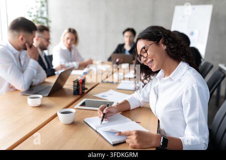 Geschäftsfrau Nimmt Notizen Sitzen Bei Business Meeting In Modern Office Stockfoto