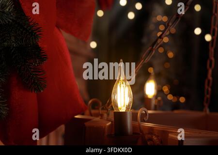 Kronleuchter-Lampenlicht in dunklem Raum, atmosphärliches Weihnachtsfeiertage-Zeitkonzept, Nahaufnahme Stockfoto