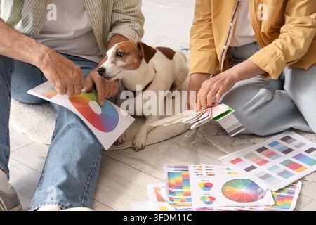 Reifes Paar mit Farbpaletten und Hund während der Reparatur in ihrem neuen Haus, Nahaufnahme Stockfoto