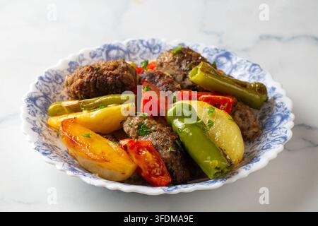 Traditionelle türkische Izmir-Köfte-Fleischbällchen mit gebackenen Kartoffeln und geröstetem Gemüse Stockfoto