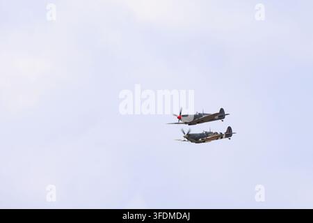 Zwei Supermarine Spitfires fliegen in enger Formation während einer Flugschau, darunter die Spitfire XVIe WZ-RR. Stockfoto