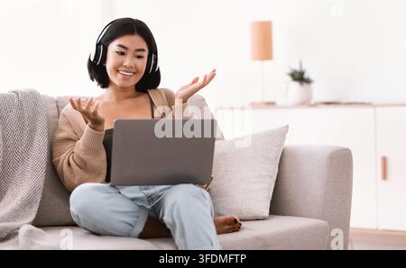 Glücklich asiatische Dame mit Laptop für Videoanruf und sprechen Stockfoto