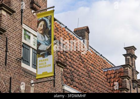 Haarlem, Niederlande - 16. August 2026: Nahaufnahme aus niedrigem Winkel der gelben Werbetafel des Frans-Hals-Museums an einer historischen Ziegelwand. Stockfoto
