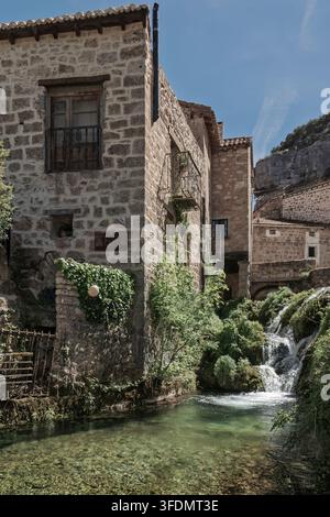 Steinhäuser und ein malerischer Wasserfall im malerischen Dorf Orbaneja del Castillo, Provinz Burgos, Kastilien und León, Spanien. Europa. Stockfoto