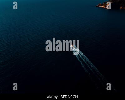 Ein einsames Schnellboot kreuzt über dunkelblaues tropisches Wasser nahe der Küste von Pattaya Chon Buri Thailand. Stockfoto