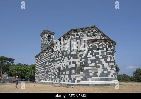 Schräge Seitenansicht der romanischen pisanischen Kirche San Michele di Murato mit ihrer grün-weiß gemusterten Steinfassade, dem Glockenturm und einem Perser Stockfoto
