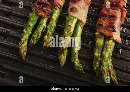 Gegrillter grüner Spargel in Speck gewickelt auf dem Grillpfannen Stockfoto