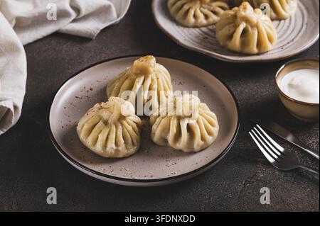 Traditionelle georgische saftige Khinkali-Teigtaschen auf einem Teller auf dem Tisch Stockfoto