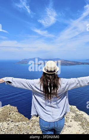 Frau auf Santorini, die Freude empfindet, umgeben von kykladischer Schönheit. Stockfoto