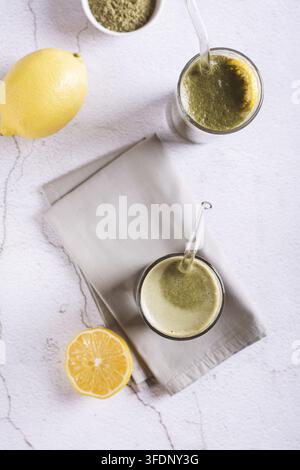 Eisgekühlte Matcha-Limonade mit Zitrone in Gläsern mit Strohhalmen auf der Tischplatte und vertikale Ansicht Stockfoto