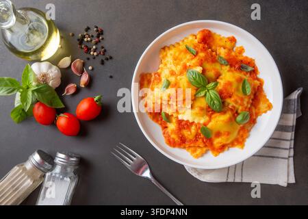Köstliche italienische Ravioli-Pasta mit frischer Tomatensauce und Basilikumblättern Stockfoto