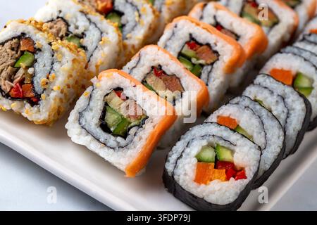 Verschiedenes gemischtes Sushi-Platte mit Lachs Maki California Rolls und Sesam-Rollen Stockfoto