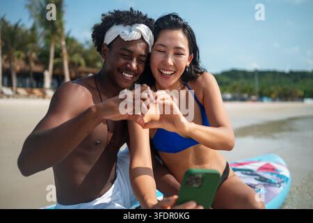 Sorgloses Paar genießt einen tropischen Strandurlaub und lacht zusammen unvergessliche Erinnerungen Stockfoto
