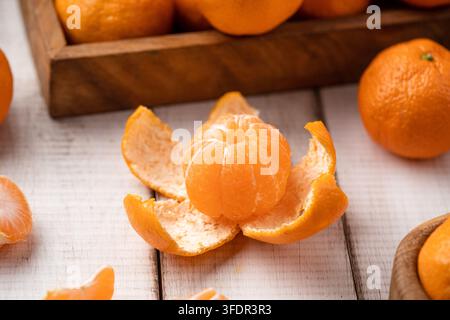 Geschälte reife Mandarine auf weißem Holztisch Stockfoto