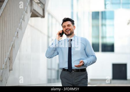 Geschäftsmann telefoniert mit dem Handy und lacht im Freien Stockfoto