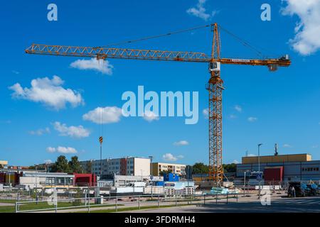 Liepaja, Lettland – 27. August 2026: Turmdrehkran auf einer städtischen Baustelle unter einem hellblauen Sommerhimmel Stockfoto