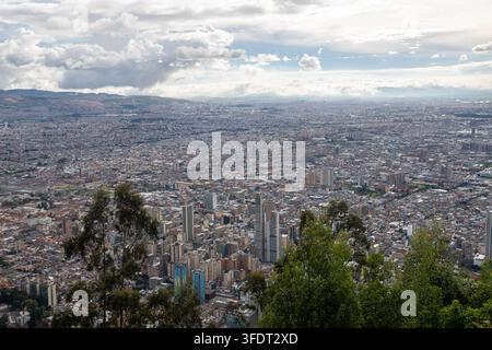Weitläufige Luftaufnahme von Bogotá, Kolumbien, die eine dichte städtische Skyline, Hochhäuser und weitläufige Viertel von einem grünen Hügel aus zeigt Stockfoto