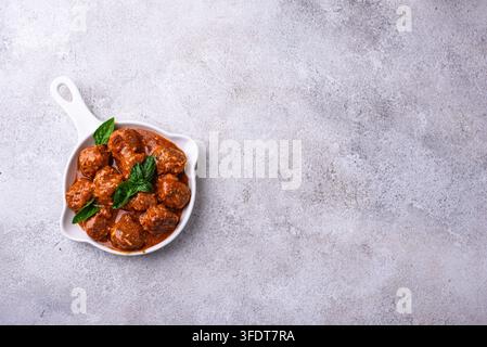 Hausgemachte Fleischbällchen in Tomatensauce in weißer Pfanne Stockfoto