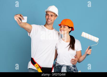 Junge Mann Und Frau In Hardhats Unter Selfie Auf Smartphone Während Der Reparatur Stockfoto