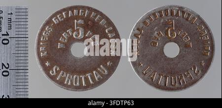 Zwei runde Metallmarken aus dem Kriegsgefangenenlager Sprottau in Schlesien, Polen, während des Ersten Weltkriegs, hergestellt von Berg & Nolte, Lüdenscheid, mit erhabener Schrift und Symbolen, darunter eine Zahl „5“ und ein flaggenähnliches Emblem auf der einen sowie ein „G“ mit einem kronenähnlichen Symbol auf der anderen. Stockfoto