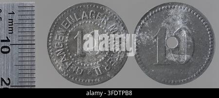 Zwei 10-Pfennig-Münzen aus der Zeit des Ersten Weltkriegs aus Münster, Deutschland, mit einem zentralen Loch und erhabener Schrift, ausgestellt als Kriegsmünzen während des Konflikts, neben einem Metalllineal zur Größenbestimmung platziert. Stockfoto