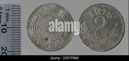 Zwei Münzen aus der Zeit des Ersten Weltkriegs aus Frankenthal, Deutschland, datiert auf 1918, eine mit einem Schild mit einem Dreieck und die andere mit der Zahl „2“ und blättrigen Zweigen, ausgegeben als Kriegsmünzen während des Konflikts. Stockfoto