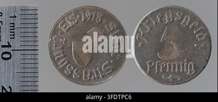 Zwei Münzen aus der Zeit des Ersten Weltkriegs aus Straßburg, eine 5-Pfennig-Münze mit Schild- und Helmdesign und eine weitere mit einer Zahl, die Anzeichen von Abnutzung aufweist, ausgegeben von der Stadt Straßburg während des Krieges. Stockfoto