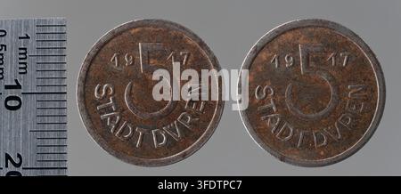 Zwei Münzen aus der Zeit des Ersten Weltkriegs aus Düren, Deutschland, neben einem Metalllineal zur Größenvergleichung. Stockfoto