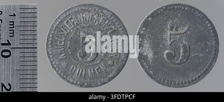 Zwei Münzen aus der Zeit des Ersten Weltkriegs aus Dülmen, Deutschland, mit der Zahl 5, neben einem Metalllineal mit Millimeterteilungen, in einer vergleichenden Anordnung. Stockfoto