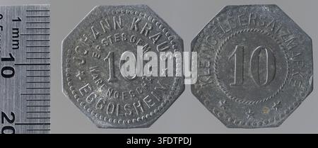 Zwei Metallmünzen aus der Zeit des Ersten Weltkriegs, etwa 20 mm breit, mit erhabener Schrift und Zahlen, darunter die Zahl „10“ und Texte wie „JOHANN KRAUS“ und „EGGOLSHEIM“ auf der einen sowie „KRIEGSLEERSAZMUNZE“ auf der anderen, geschaffen von L. Chr. Lauer, einem deutschen Autor und vermutlich Hersteller, als private Kriegsmünzen für Johann Kraus, einen Kaufmann in Eggolsheim, Deutschland. Stockfoto