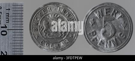 Zwei Kriegsmünzen aus der Zeit des Ersten Weltkriegs aus Colmar, Haut-Rhin, herausgegeben von der Backer Innung Colmar, einer Bäckerinnung, mit erhabener Schrift und Designs, darunter ein zentrales Emblem mit zwei Tieren, die einen Schild flankieren, und einer großen Zahl. Stockfoto