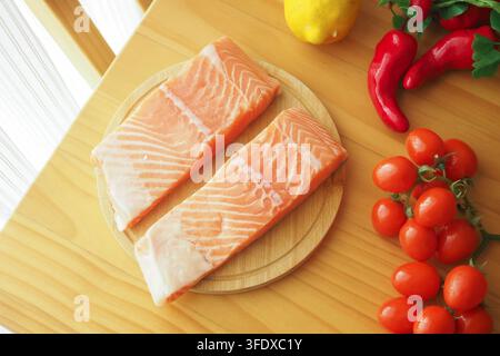 Lachs und Gemüse auf Schneidebrett Stockfoto