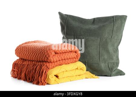 Gemütlicher Wohnkomfort und Innendesign, gefaltete Strickdecken und dekoratives Kissen für die Herbstwohnzimmerdekoration isoliert auf weißem Hintergrund Stockfoto